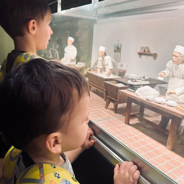 Enfants observant une maquette de boulangerie ancienne