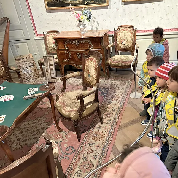Enfant souriant écoutant un tableau interactif raconter une histoire au château.