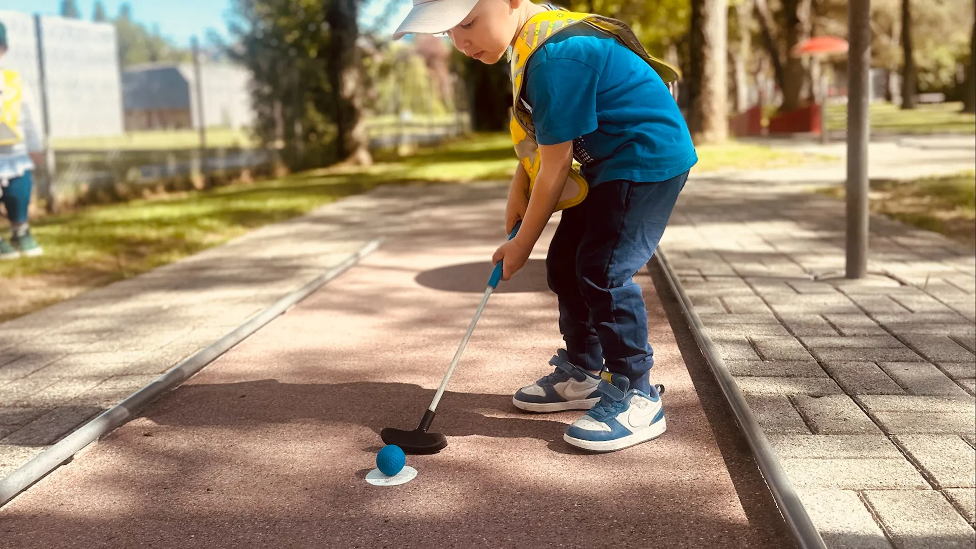 Enfant de la crèche Le Microcosme à Lausanne jouant au mini-golf lors d’une activité de motricité ludique.