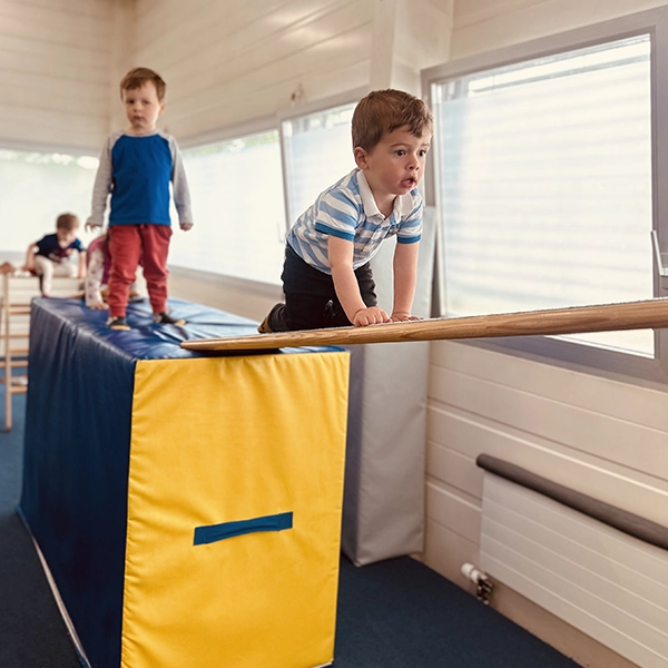 Un enfant grimpe sur un module en mousse dans l’espace ruche sportive à la crèche Le Microcosme à Lausanne.