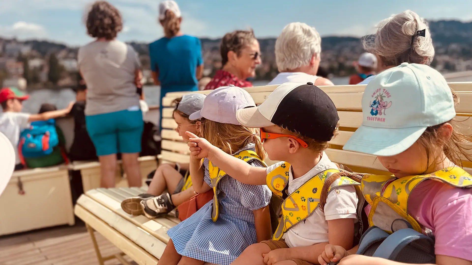 Enfants de la crèche Le Microcosme savourant une glace après une sortie en bateau sur le lac Léman à Lausanne, entre rires et émerveillement.
